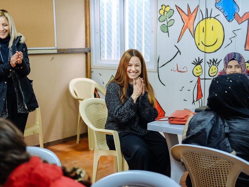 En un aula, un grupo de mujeres sonríe y aplaude