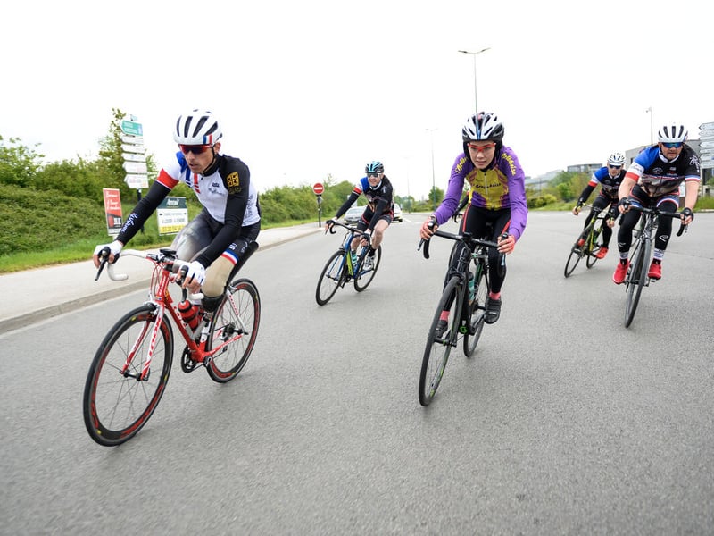 Un grupo de personas anda en bicicleta; todas llevan cascos.