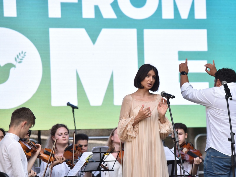 Una cantante dando un concierto con una orquesta juvenil.