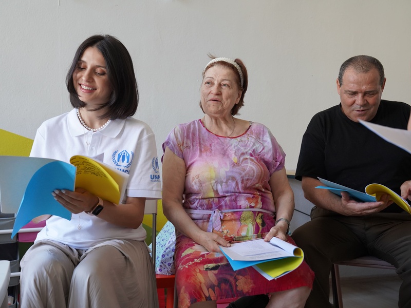 Tres personas, dos mujeres y un hombre, están leyendo partituras sentadas una a lado de la otra