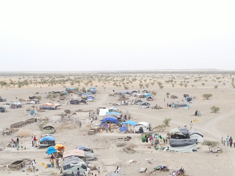Carpas construidas con lonas y otros materiales en medio de una zona desértica