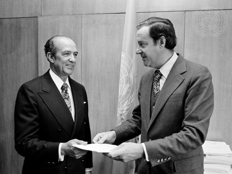 Foto en blanco y negro de dos hombres que sostienen un documento