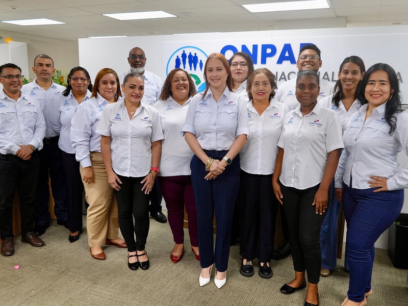 Diez mujeres y cuatro hombres de pie con uniforme en una oficina