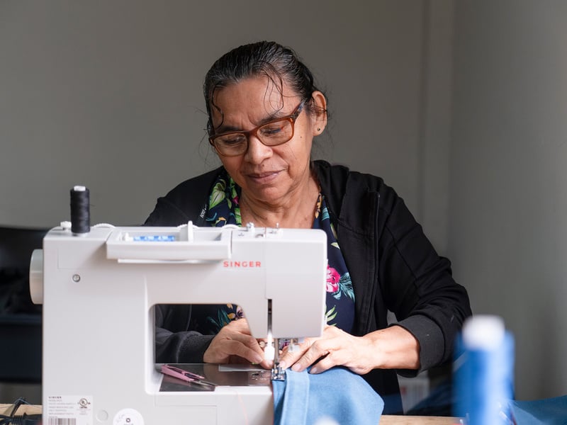 Una mujer detrás de una máquina de coser