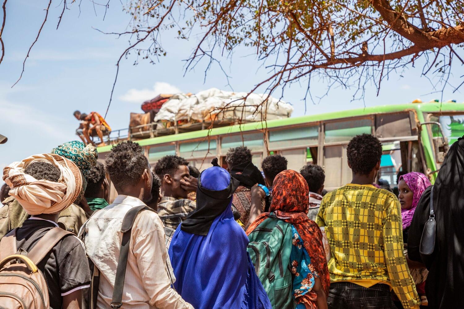 Un grupo de personas somalíes refugiadas hace fila, en Gool, Etiopía, para abordar los autobuses que van al asentamiento de Mirqaan.
