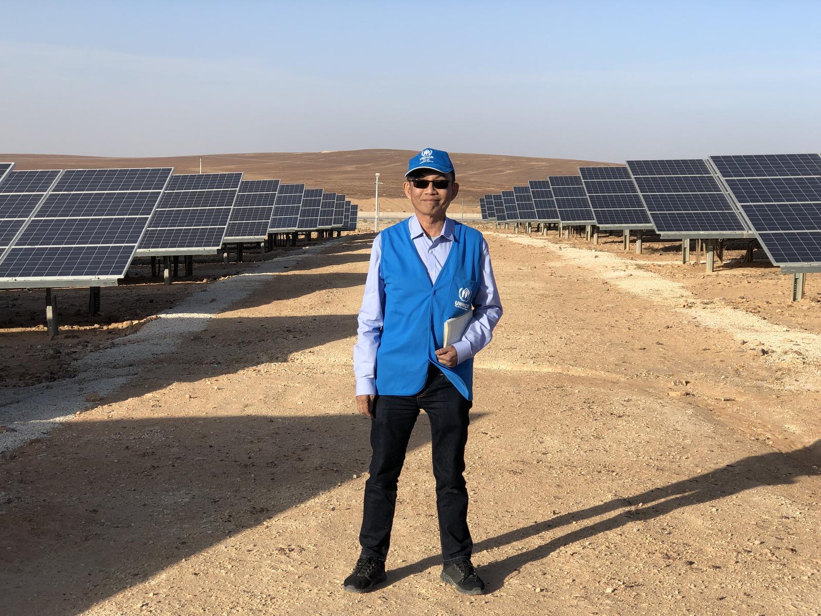 Un hombre está de pie en una central solar.