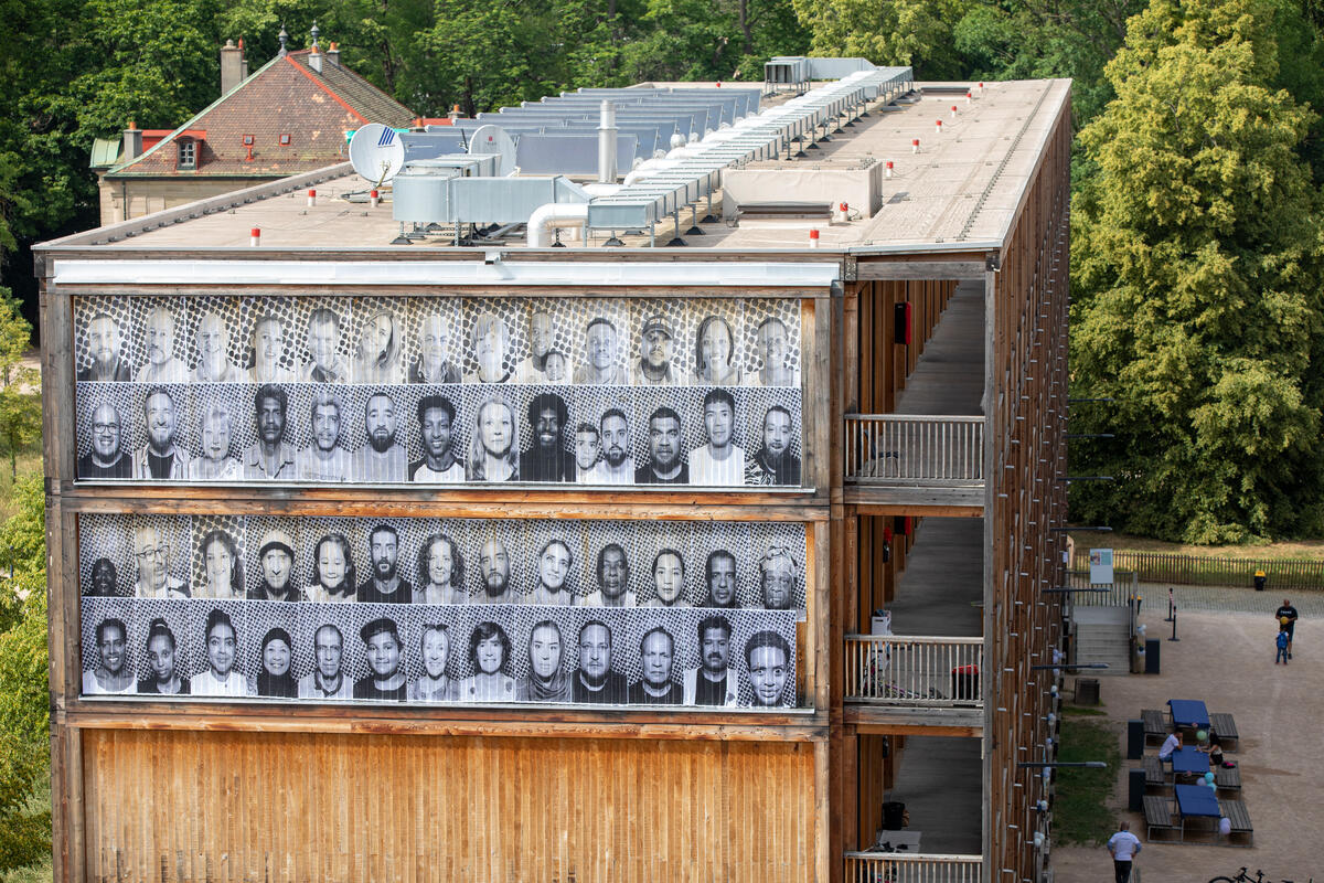 Retratos de residentes cuelgan de la fachada del centro colectivo del centro de Ginebra como parte de un proyecto del artista francés JR.