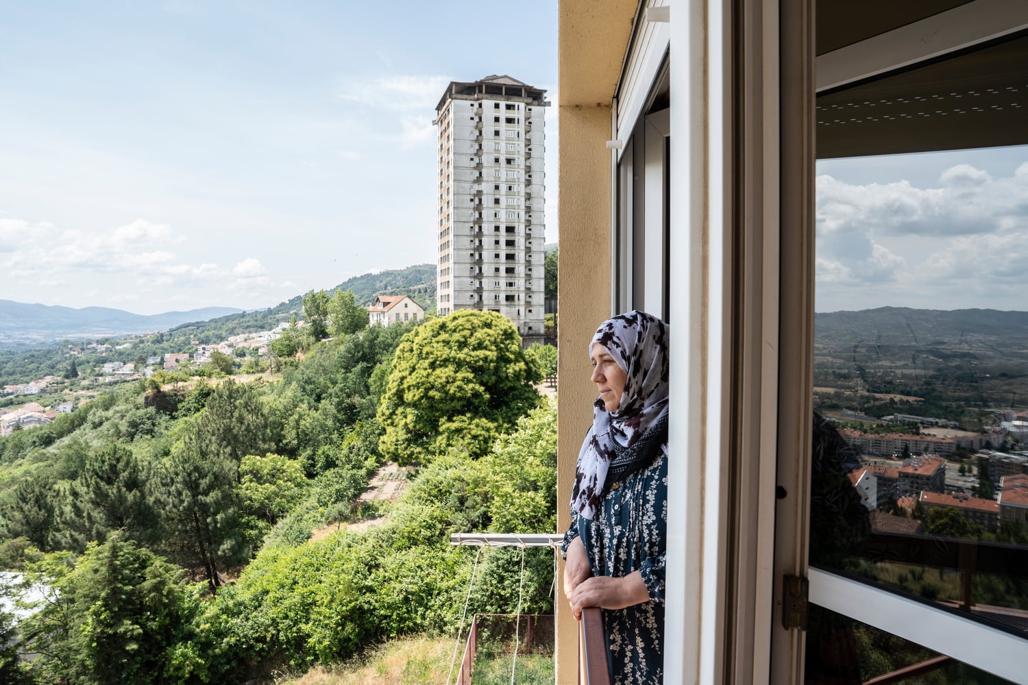 Una mujer mira por la ventana de un rascacielos