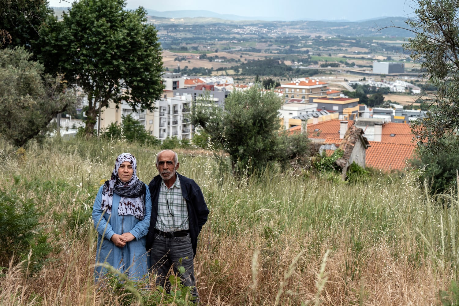 Muna y Moustafa Albakkar en una colina cubierta de hierba sobre la ciudad de Covillana