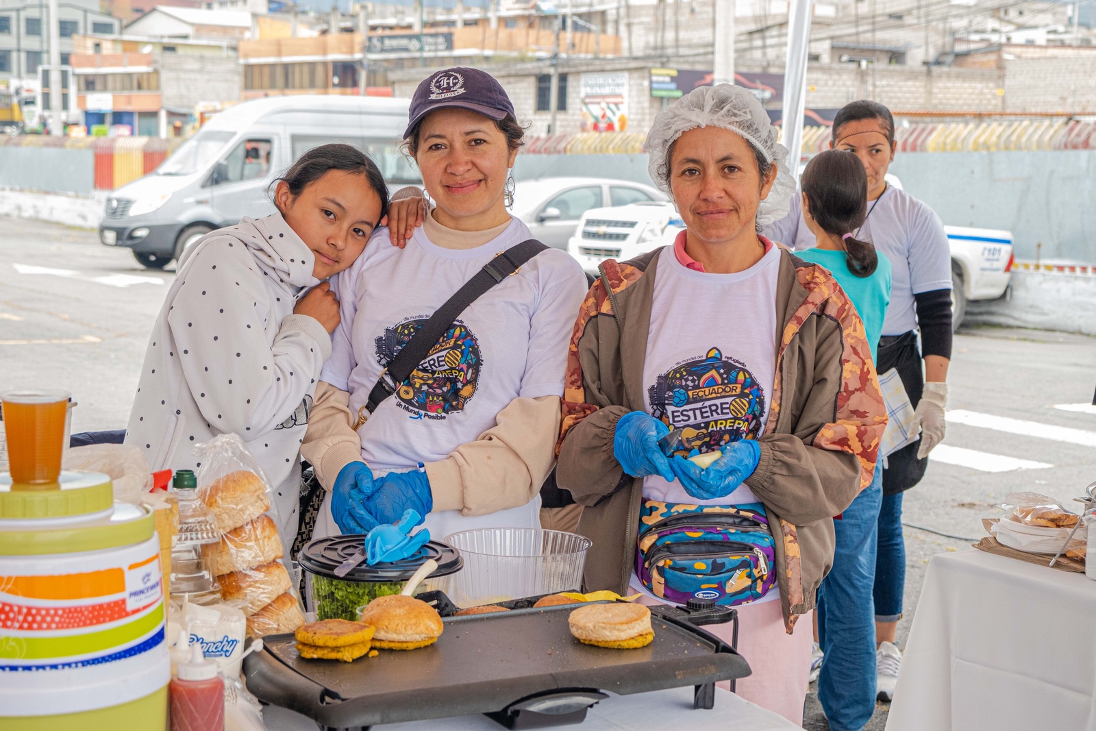 Una niña y dos mujeres atienden un puesto de comida