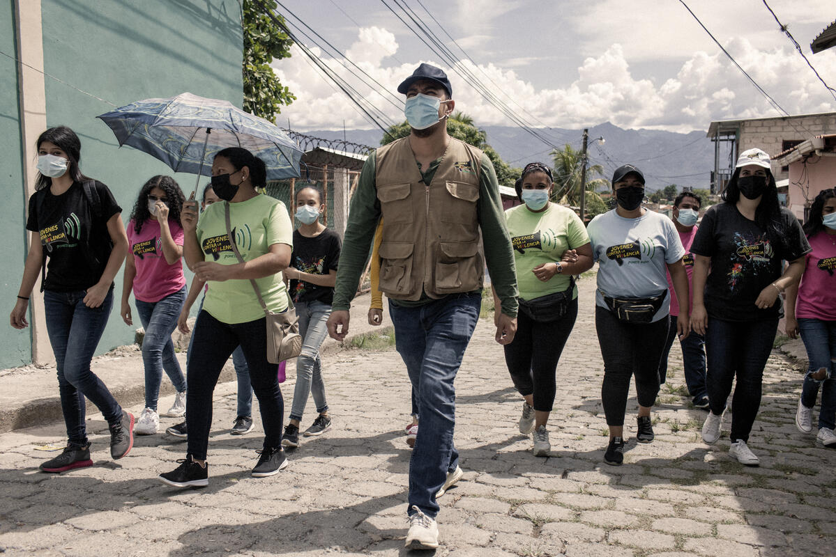 Un grupo de personas con cubrebocas camina por la calle