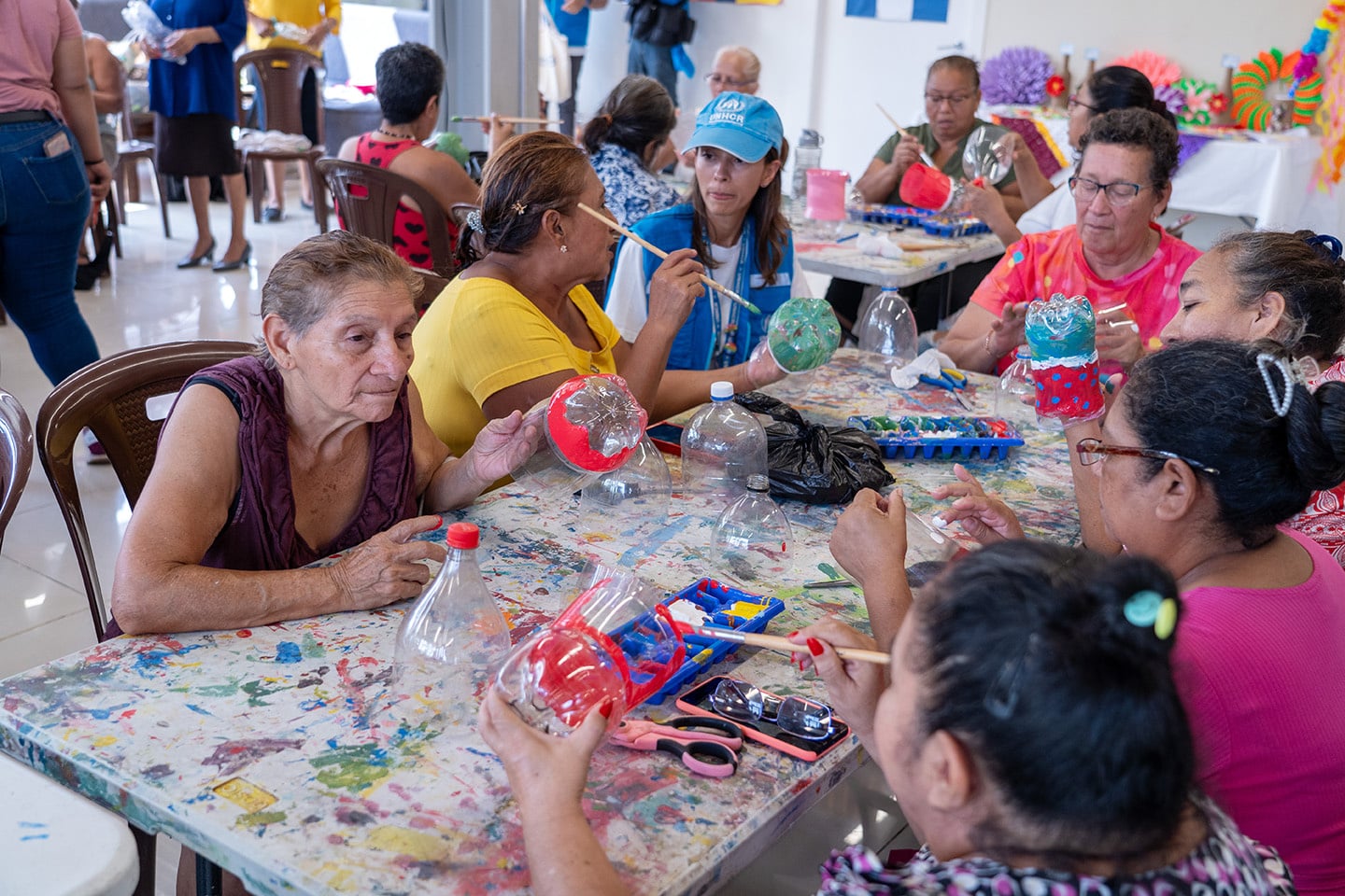 Un grupo de personas mayores sentadas a una mesa haciendo actividades lúdicas.
