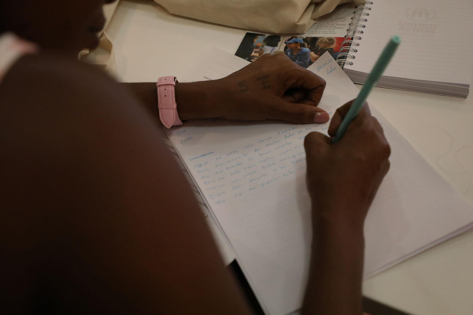 Primera plana de unas manos escribiendo una carta.