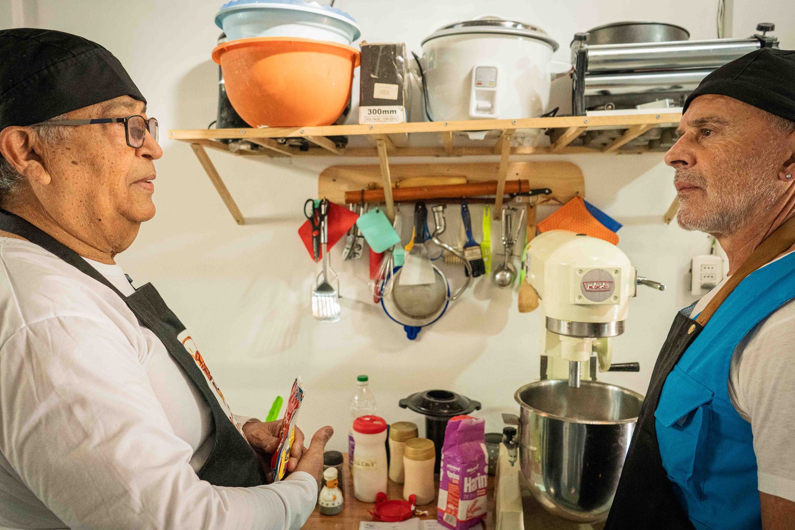 Dos hombres hablando en una cocina.