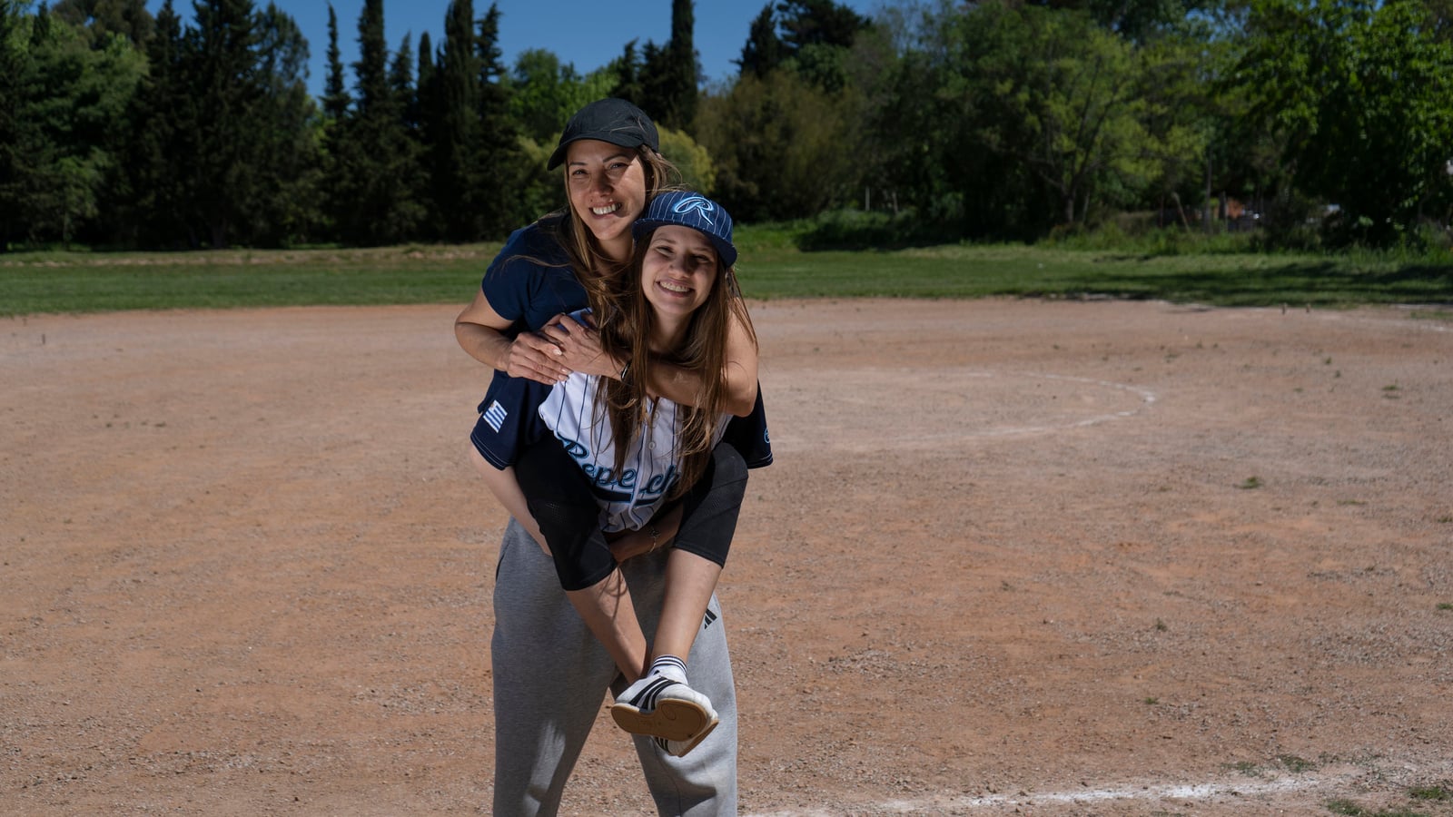 Una mujer carga a otra en su espalda en un campo de juego