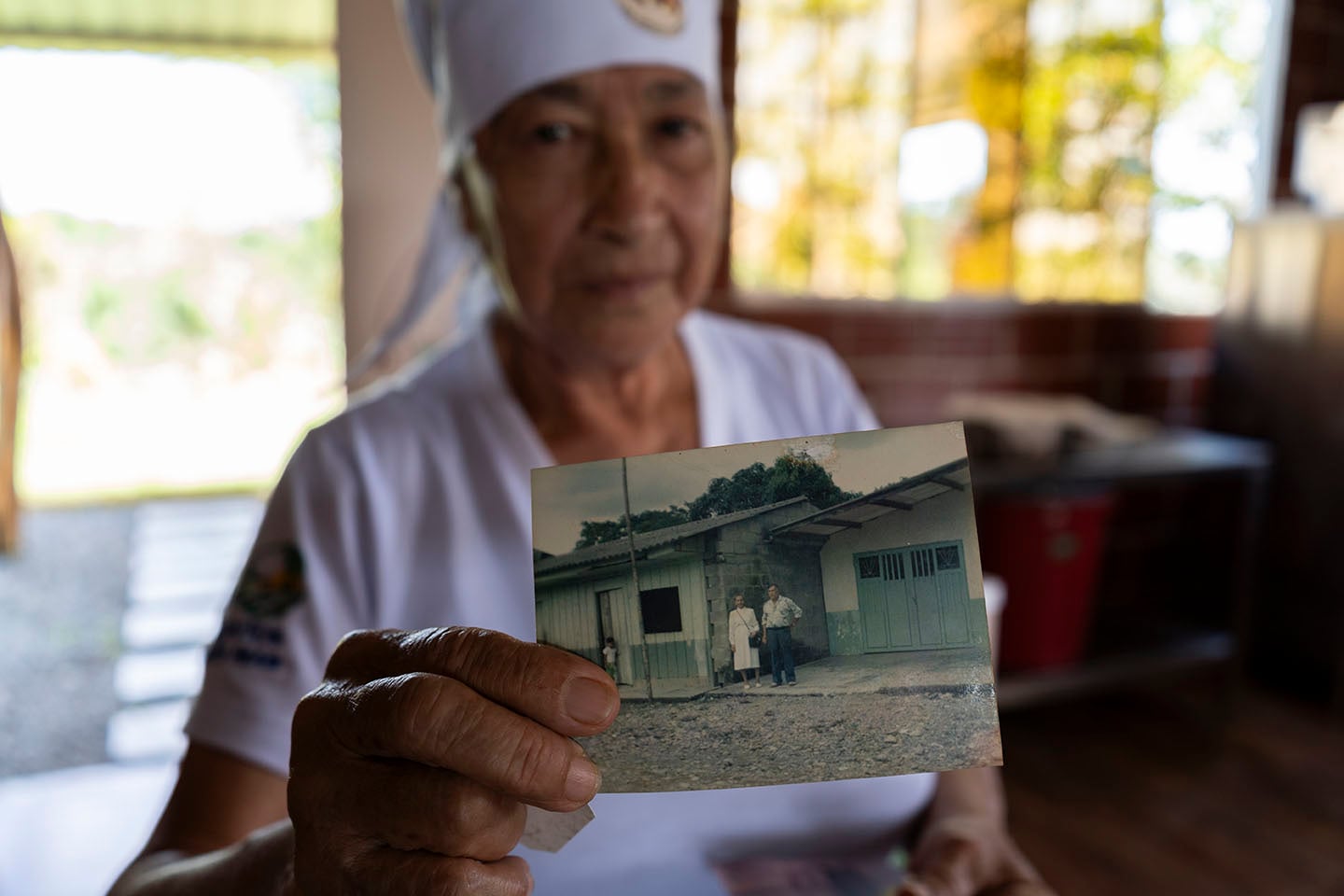 Una mujer muestra una vieja foto.