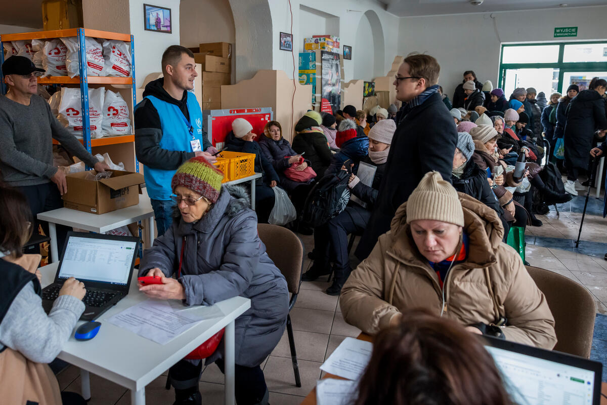Dmytro, monitor de protección, charla con Aleksander Magdenko, coordinador en el punto de distribución de asistencia humanitaria de Slavic Mission, en Cracovia.