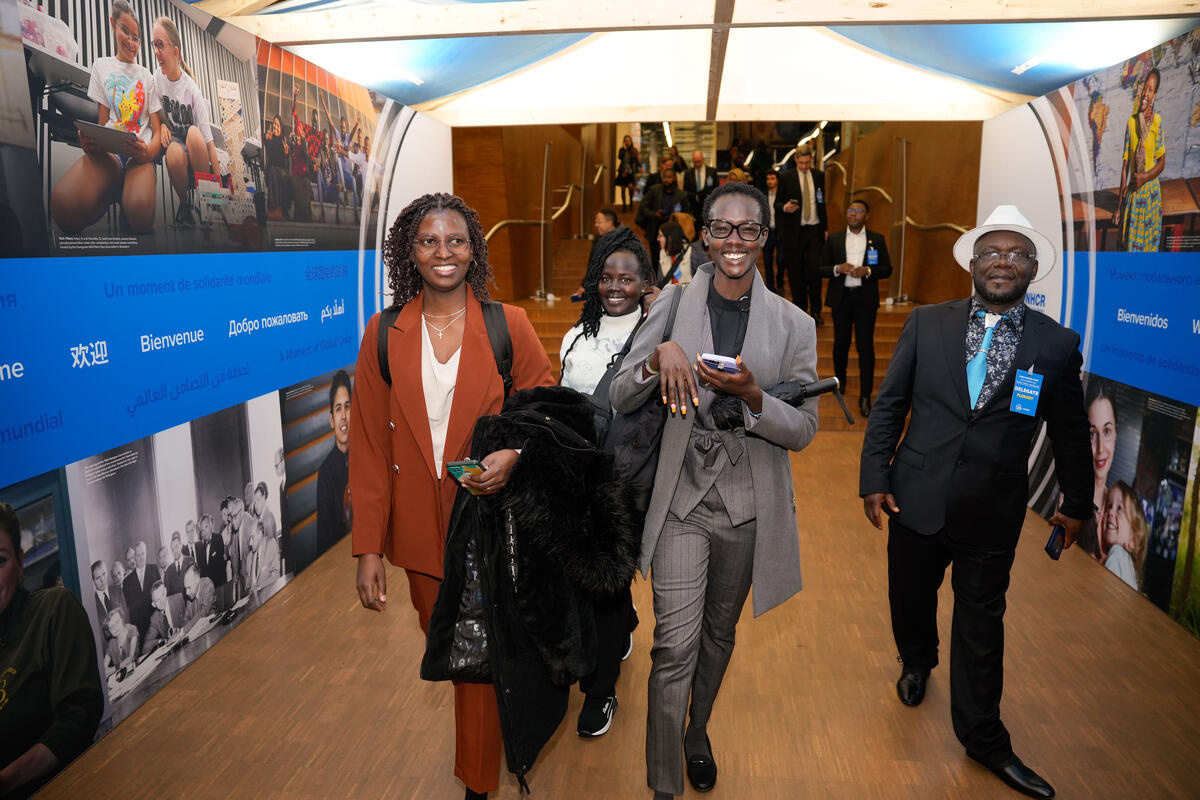 Participantes pasan por la Welcome House de ACNUR en el centro de convenciones Palexpo. 