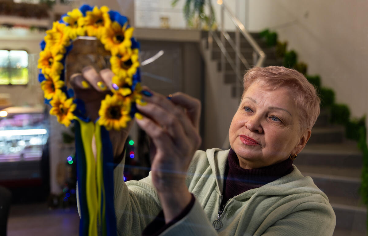 Una mujer de cabello corto acomoda unos girasoles