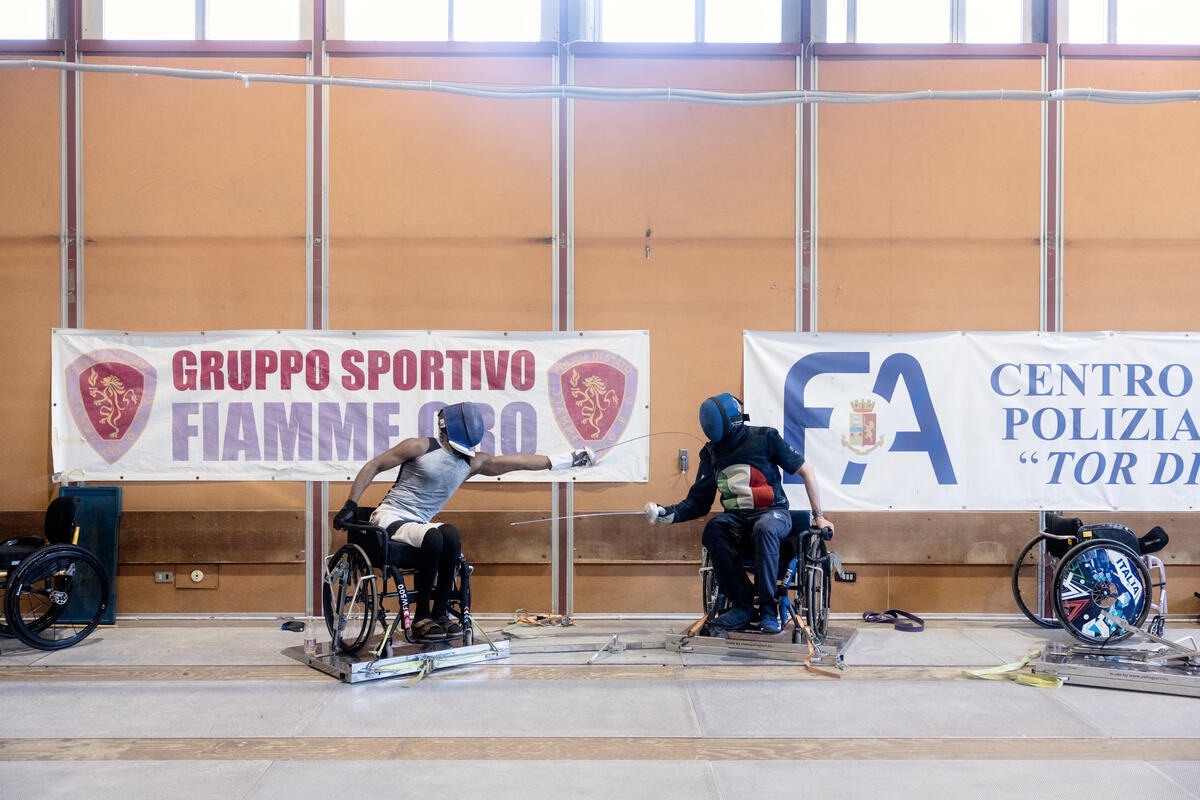 Dos hombres en silla de ruedas practican esgrima