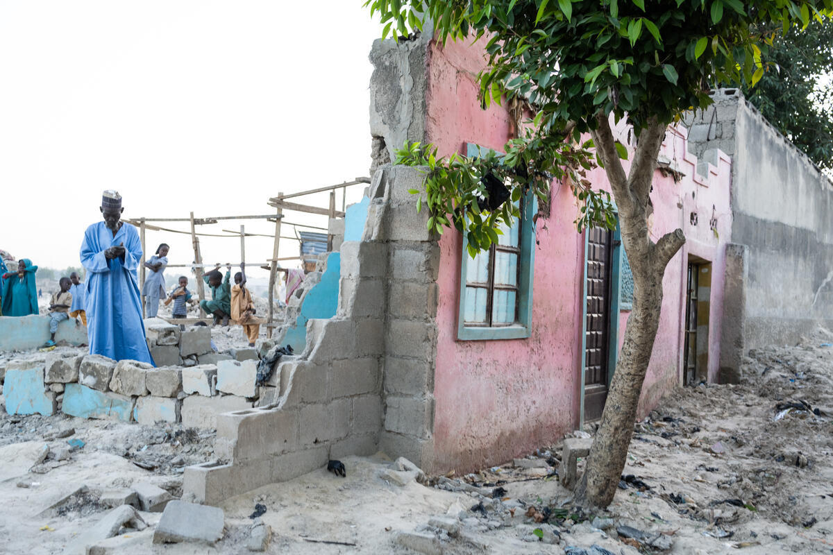 Un hombre en las ruinas de una casa de la que solo queda en pie la fachada