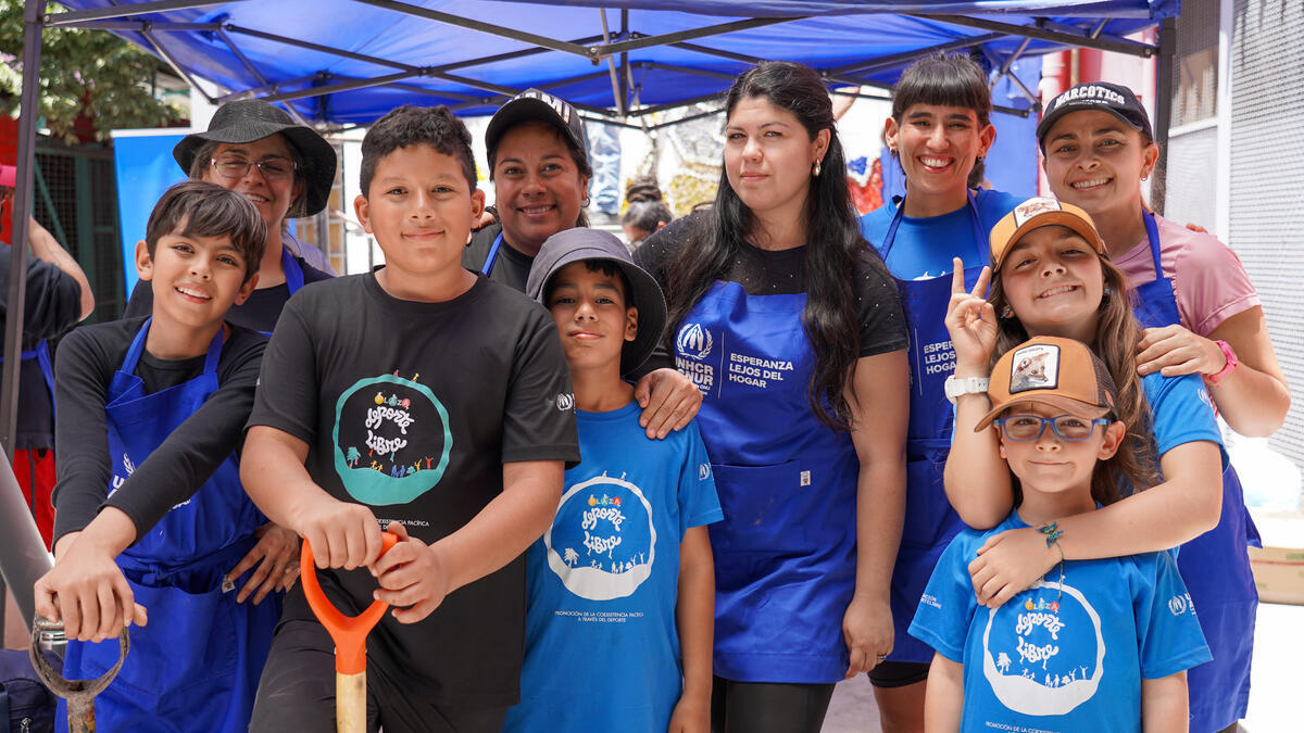 Grupo de voluntarios y voluntarias comparten en el segundo día de la creación del mural.  