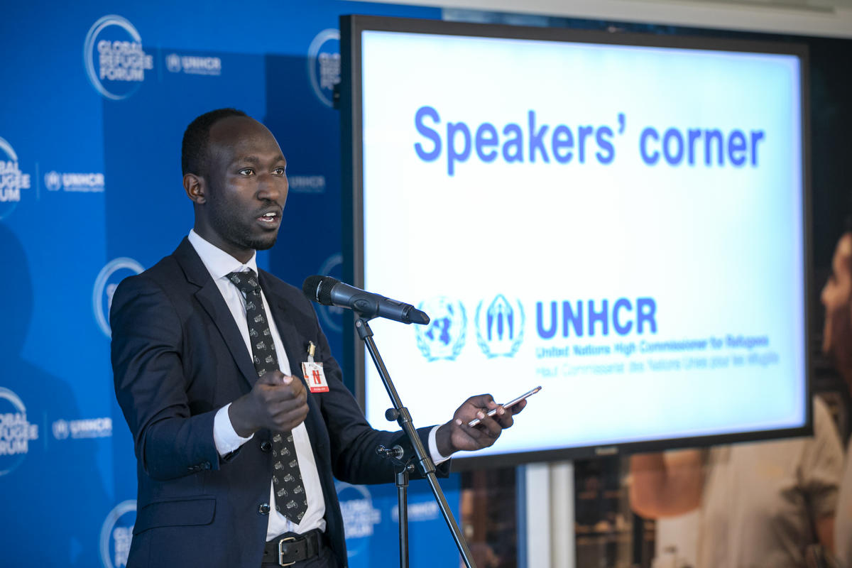 Un hombre vestido de traje y corbata, da un discurso durante el Foro Mundial sobre los Refugiados