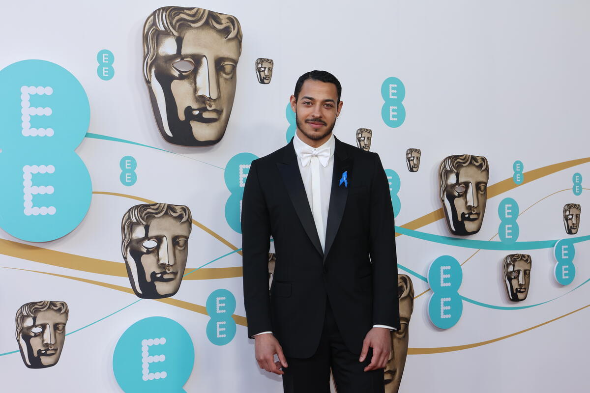 United Kingdom. Actor Daryl Mcormack wearing a blue ribbon in solidarity with refugees at the EE BAFTA Film Awards 2023