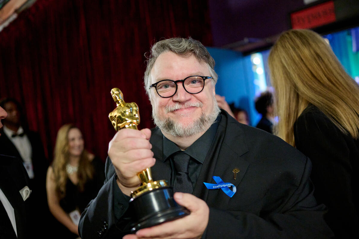 United States. Guillermo del Toro poses backstage with the Oscar for Animated Feature Film during the live ABC telecast of the 95th Oscars and wears a blue ribbon in solidarity with refugees