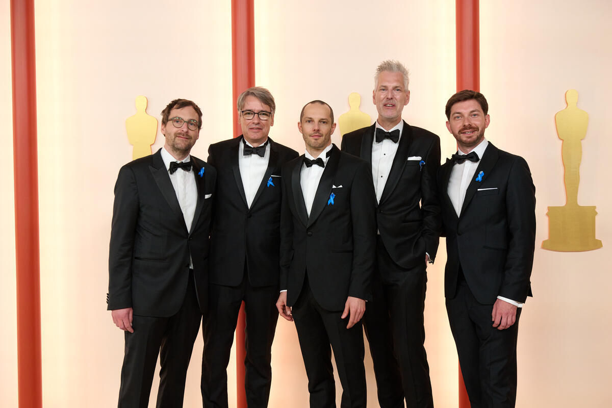 United States. Oscar nominees Lars Ginzel, Frank Kruse, Markus Stemler, Stephan Korte, and Viktor Prášil arrive on the red carpet of the 95th Oscars and wear blue ribbons in solidarity with refugees