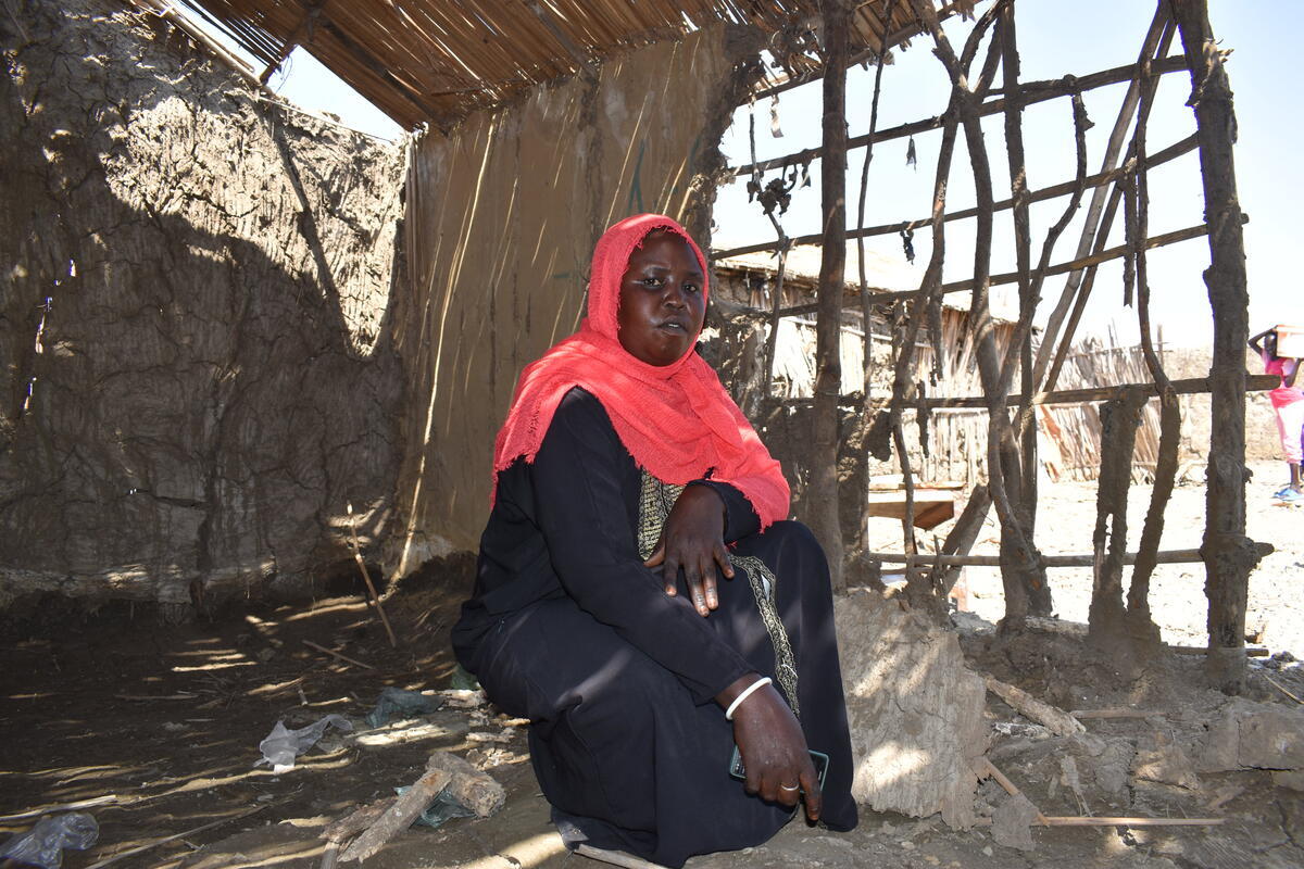 Sudan. Nyalan sits where she once had a bed and a roof to keep her family safe and sheltered in Al Redis 1 refugee camp