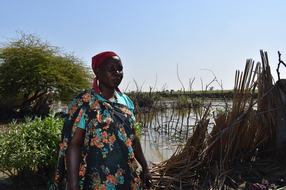 Sudan. Triza sadly stares at what is left of her shelter in Al Redis 1 refugee camp