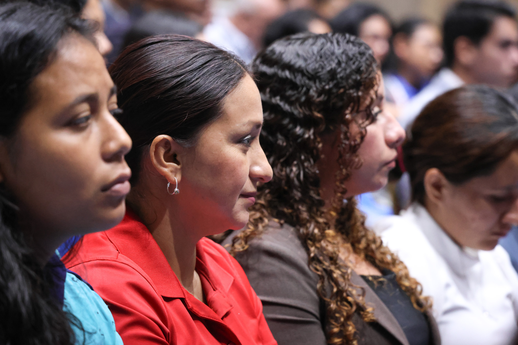 Cuatro mujeres de perfil, de izquierda a derecha visten color celeste, rojo, negro y blanco.