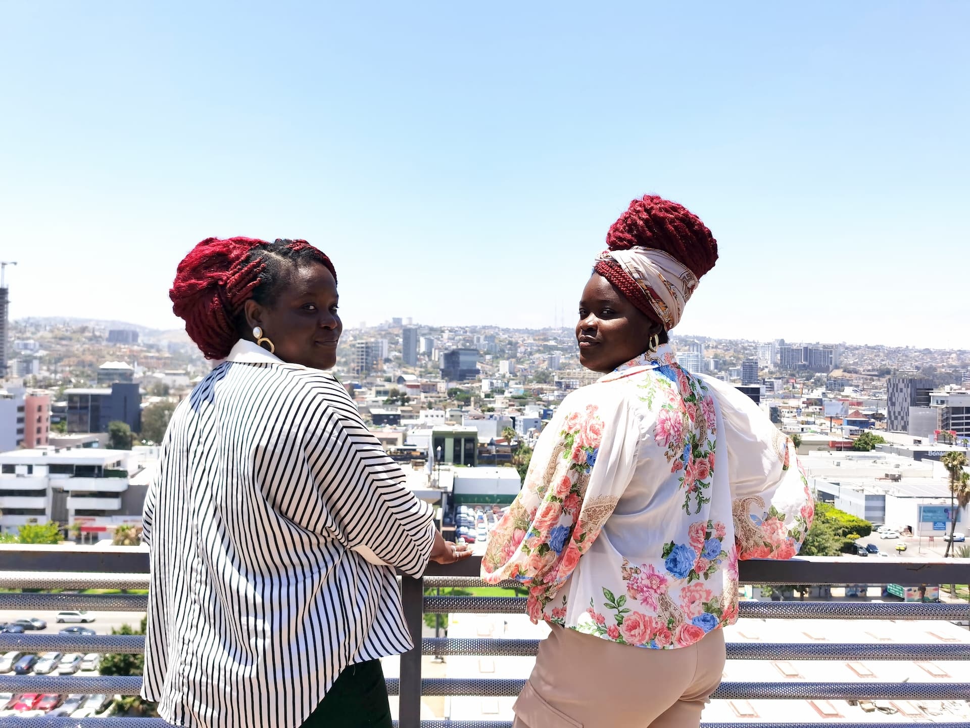Las hermanas Valcin en Tijuana miran el panorama de la ciudad desde una terraza.