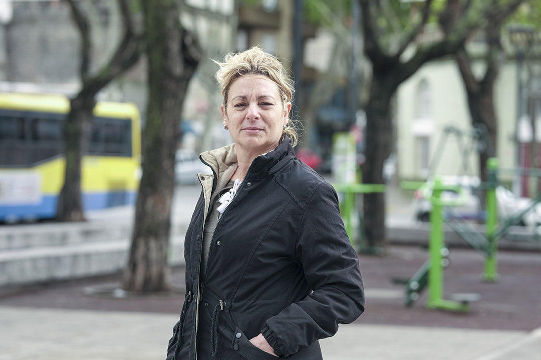 Una mujer posa para una foto en una plaza.
