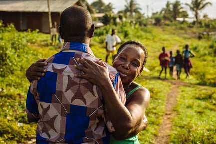 Un refugiado de Côte d'Ivoire recibe un abrazo de su tía al volver a casa