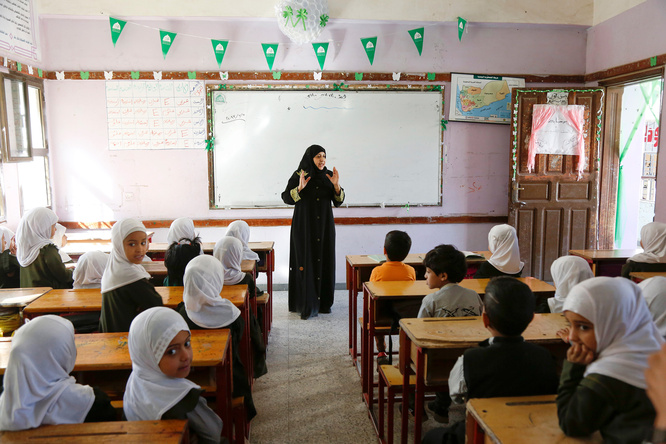 Una mujer que lleva puesto el hijab da una clase en un aula mixta