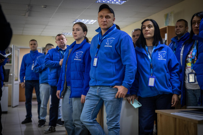 Un grupo de personas de chaqueta azul posa para la cámara.