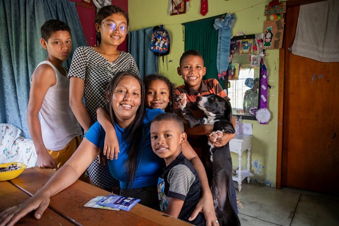 Una mujer con sus cinco hijos alrededor de una mesa en su casa
