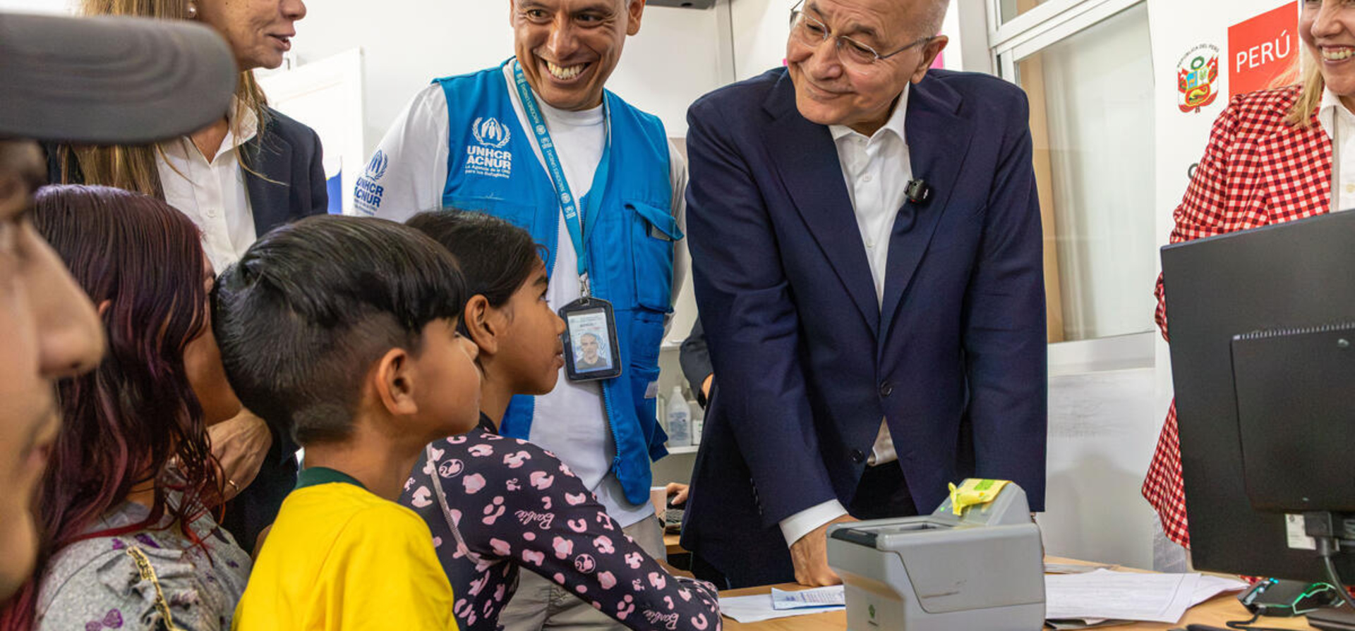 El Alto Comisionado de la ONU para los Refugiados, Barham Salih, y funcionarios de ACNUR hablan con una familia de Venezuela en un centro de protección de Lima, Perú.