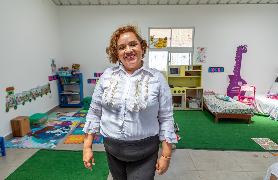 Una mujer sonriente de pie en un cuarto de juegos infantil