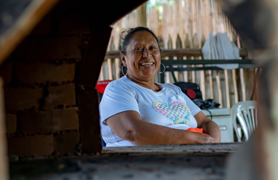 Una mujer mira hacia la cámara sonriendo.