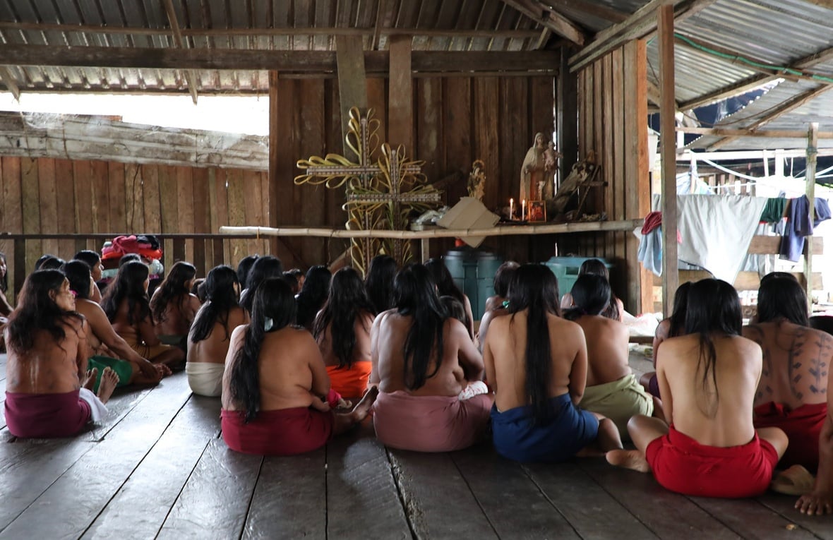 Mujeres Wounaan de espaldas frente a imágenes religiosas