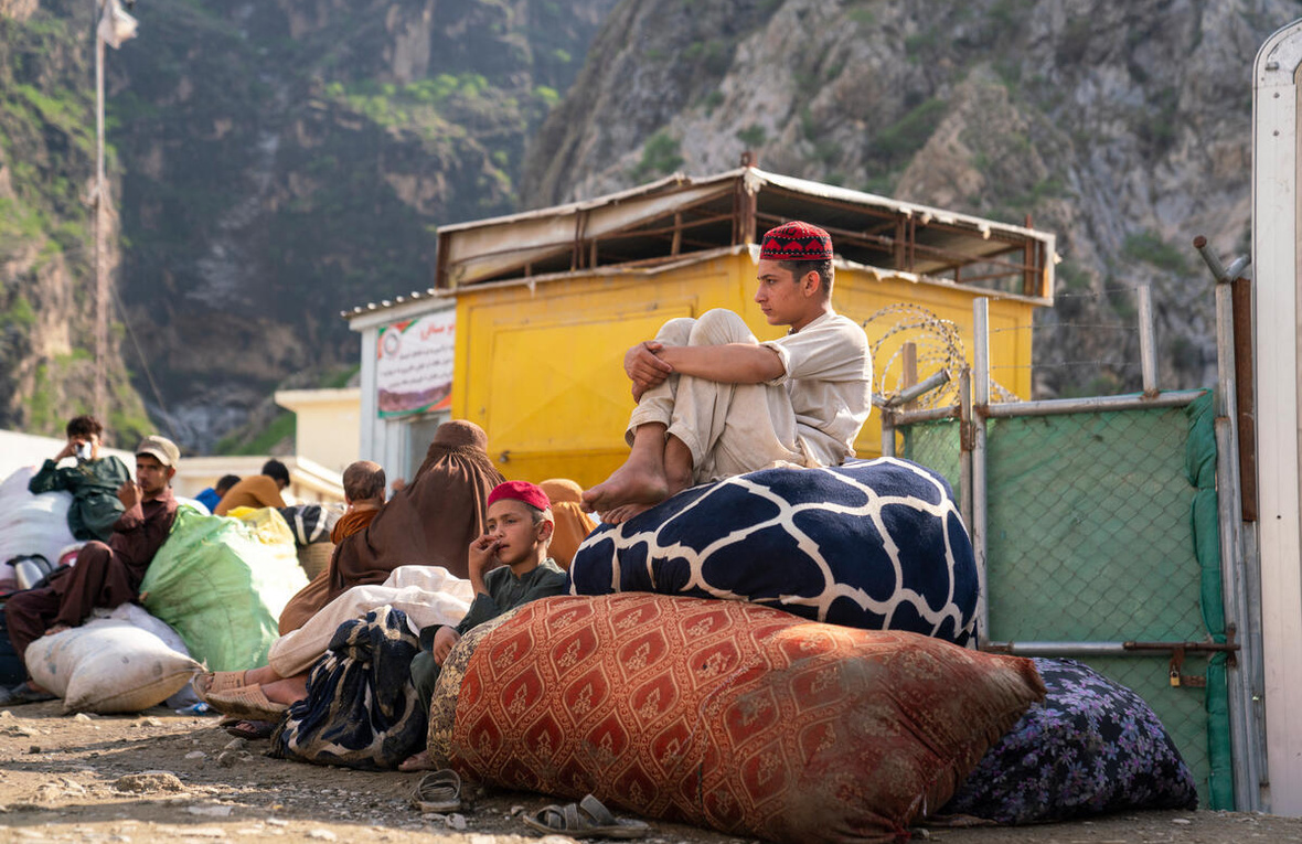 Ahmad, de 15 años, y su hermano pequeño Sahil, de 12, esperan en la frontera de Torkham entre Pakistán y Afganistán con su familia, tras retornar desde Pakistán.