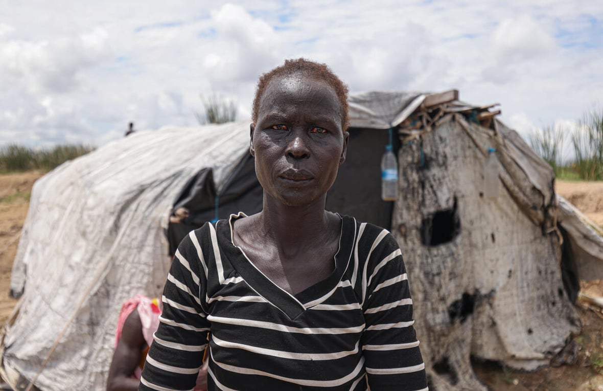 Aduot Wuoi Monjuon, desplazada interna, posa junto a su refugio en Bor, Sudán del Sur, donde se ha desplazado después de que las inundaciones la obligaran a huir de su aldea en el Estado de Jonglei, junto a su familia.