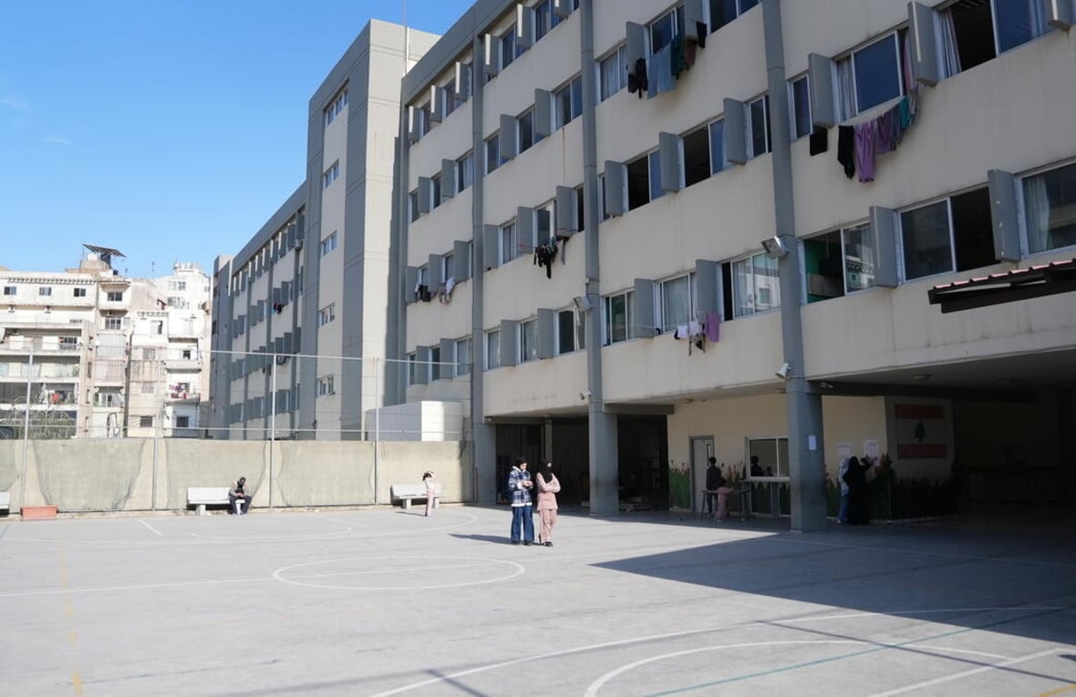 Vista de un patio en un edificio escolar con ropa tendida en cuerdas que salen por las ventanas