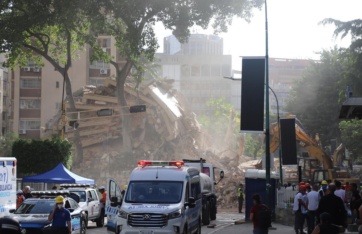 Equipos de búsqueda y rescate trabajan entre los escombros de un edificio derrumbado.