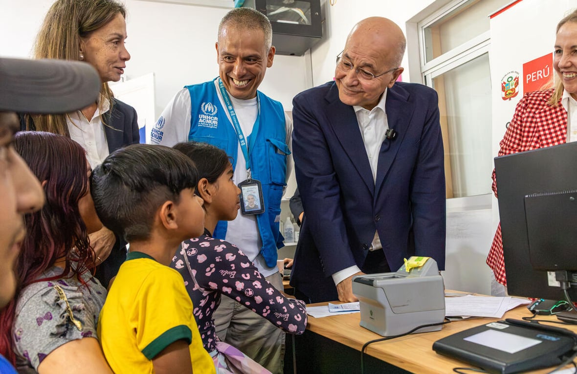 El Alto Comisionado de la ONU para los Refugiados, Barham Salih, y funcionarios de ACNUR hablan con una familia de Venezuela en un centro de protección de Lima, Perú.