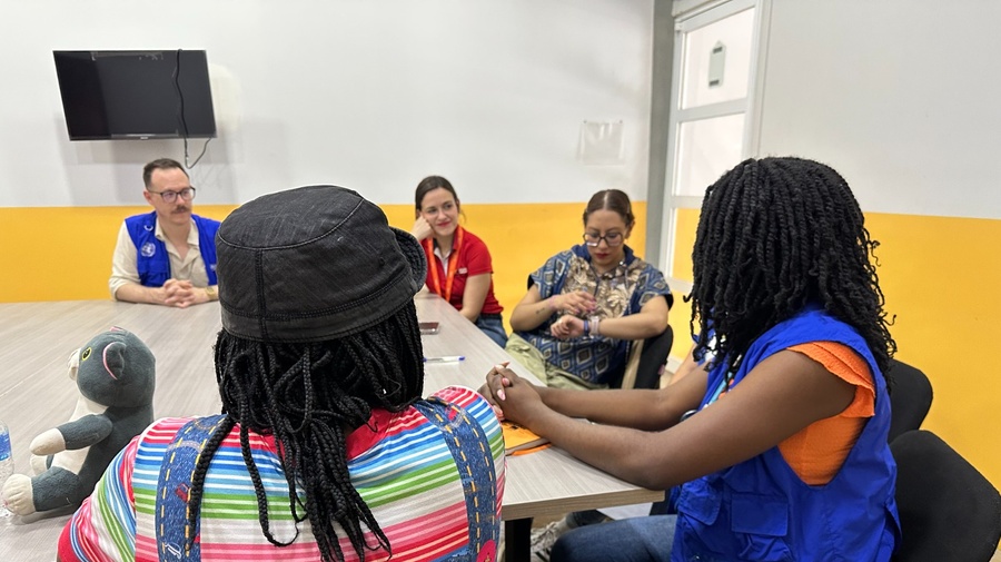 Un grupo de personas conversando sentadas alrededor de una mesa.