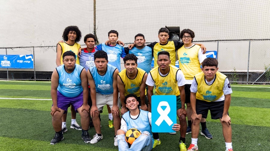 Un grupo de doce jóvenes varones posan en una cancha de fútbol 